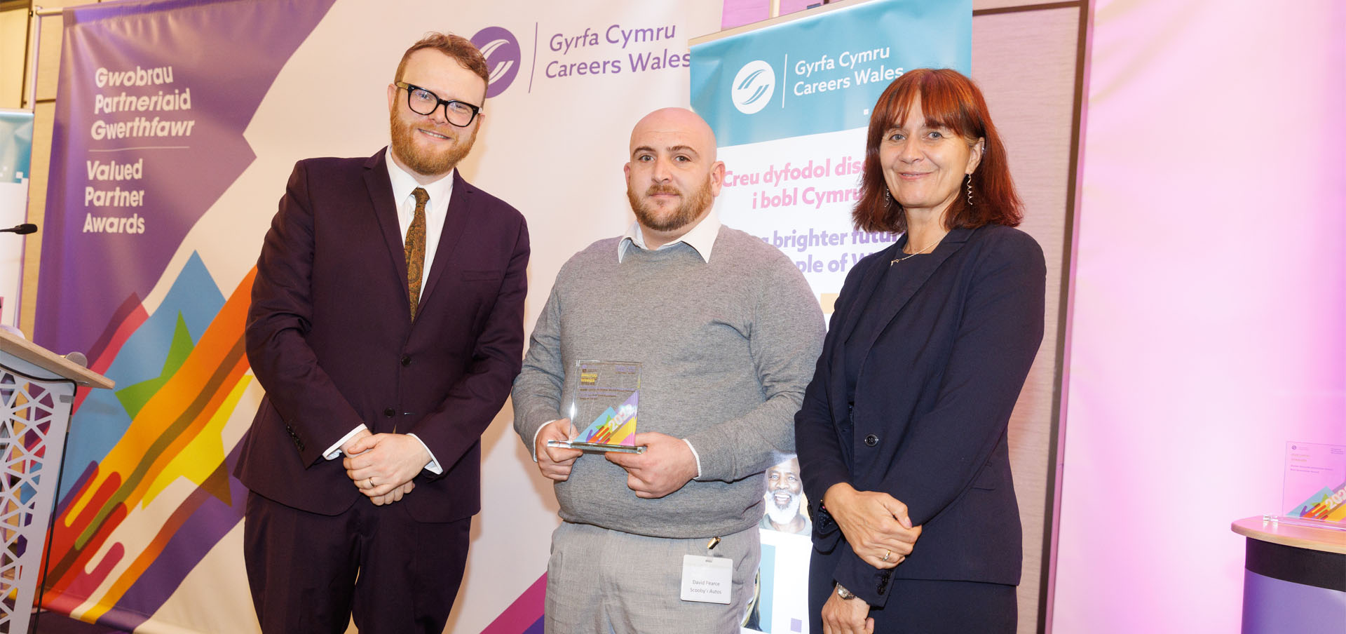 David Pearce from Scooby’s Autos being presented with their award by presenter Huw Stephens and Nikki Lawrence, Chief Executive, Careers Wales