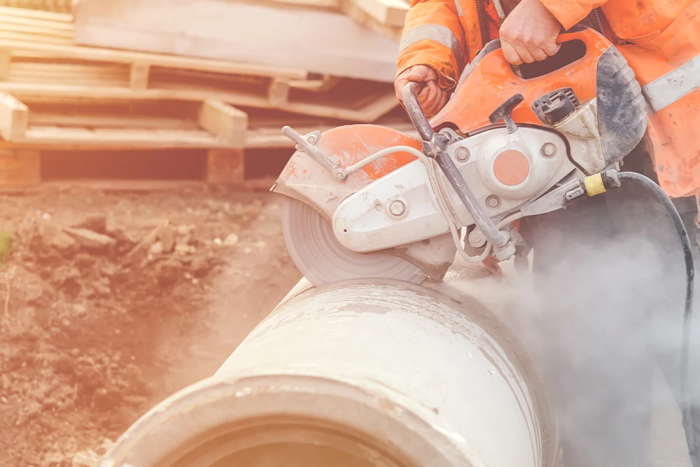 Person using a concrete tool cutter to cut large pipe